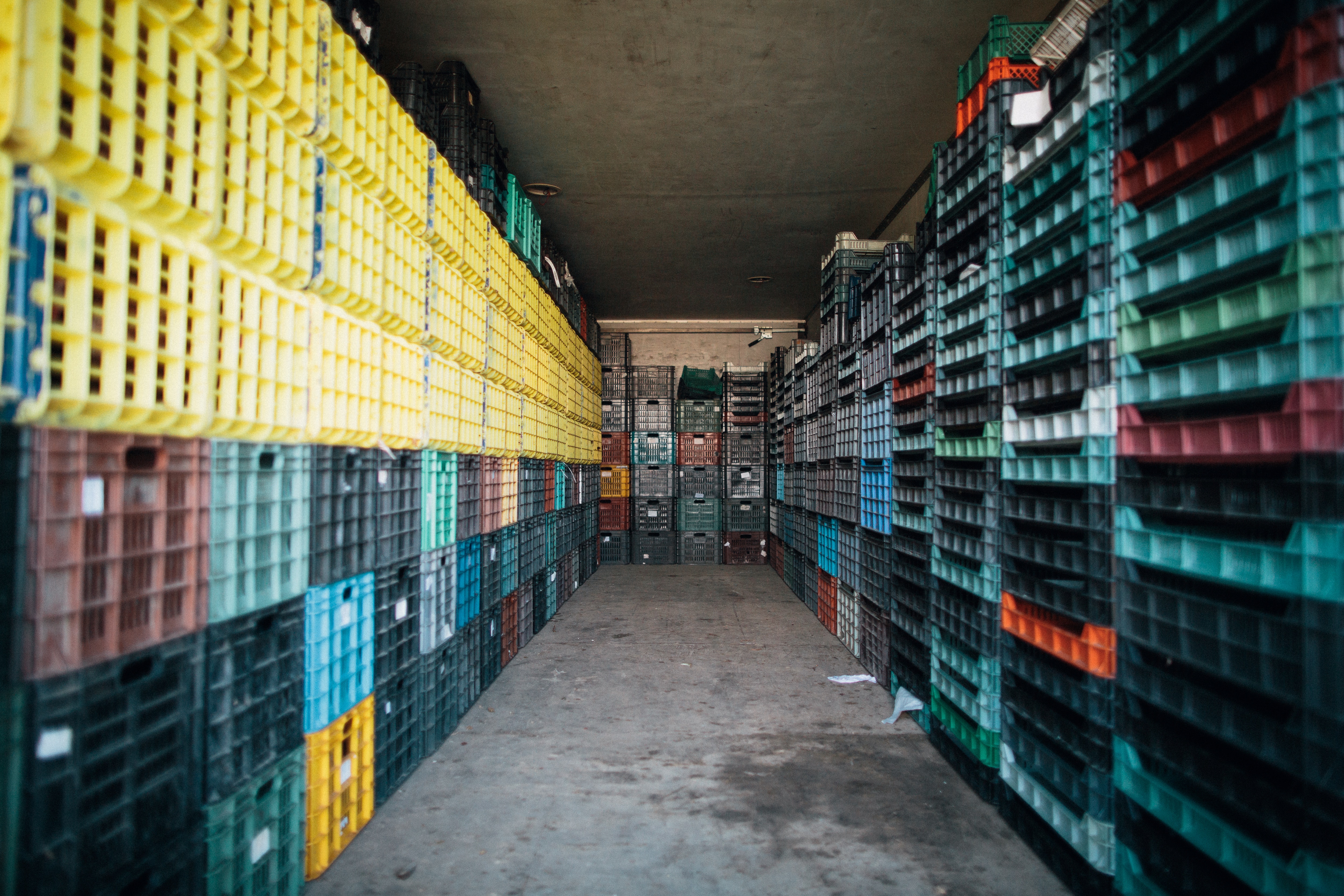 Photo by Bence Szemerey (https://www.pexels.com/photo/corridor-between-piles-of-containers-in-storehouse-7513430/)